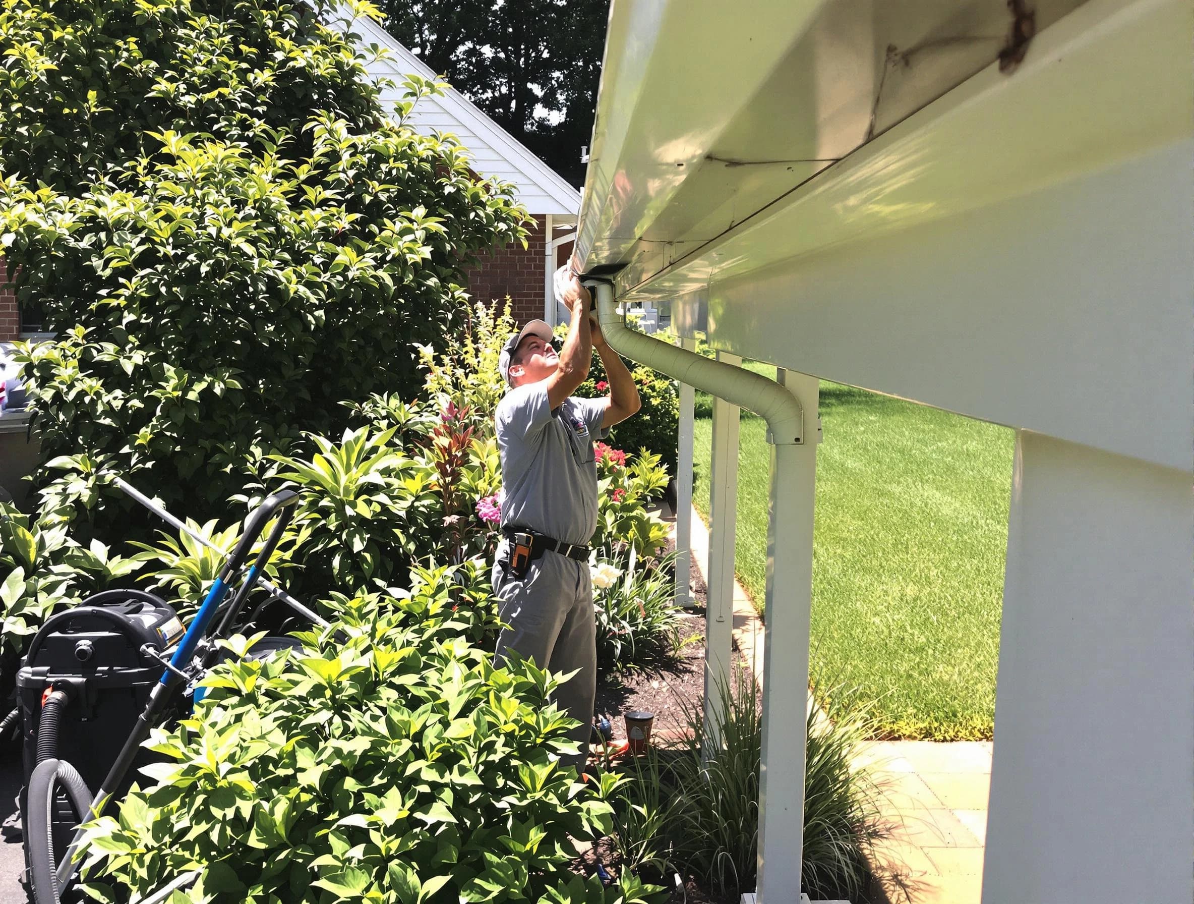 Technician flushing a blockage from a downspout in Wadsworth, OH